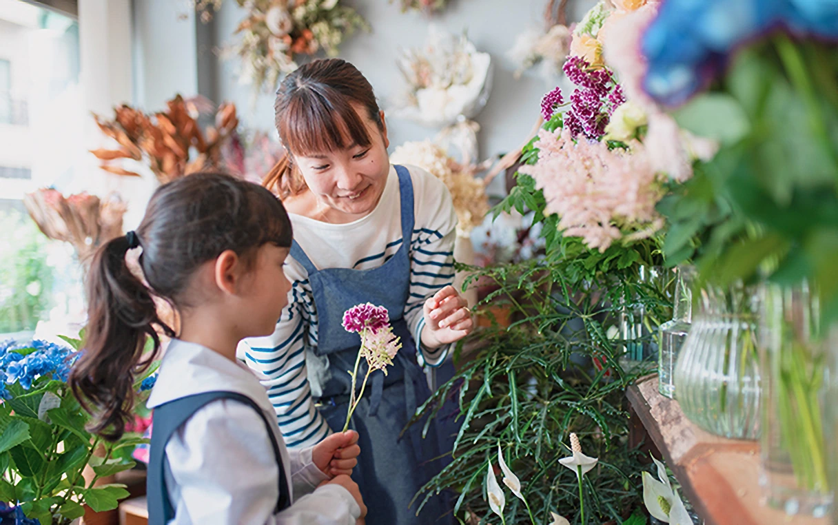 A picture of a lady and a girl in a flower shop